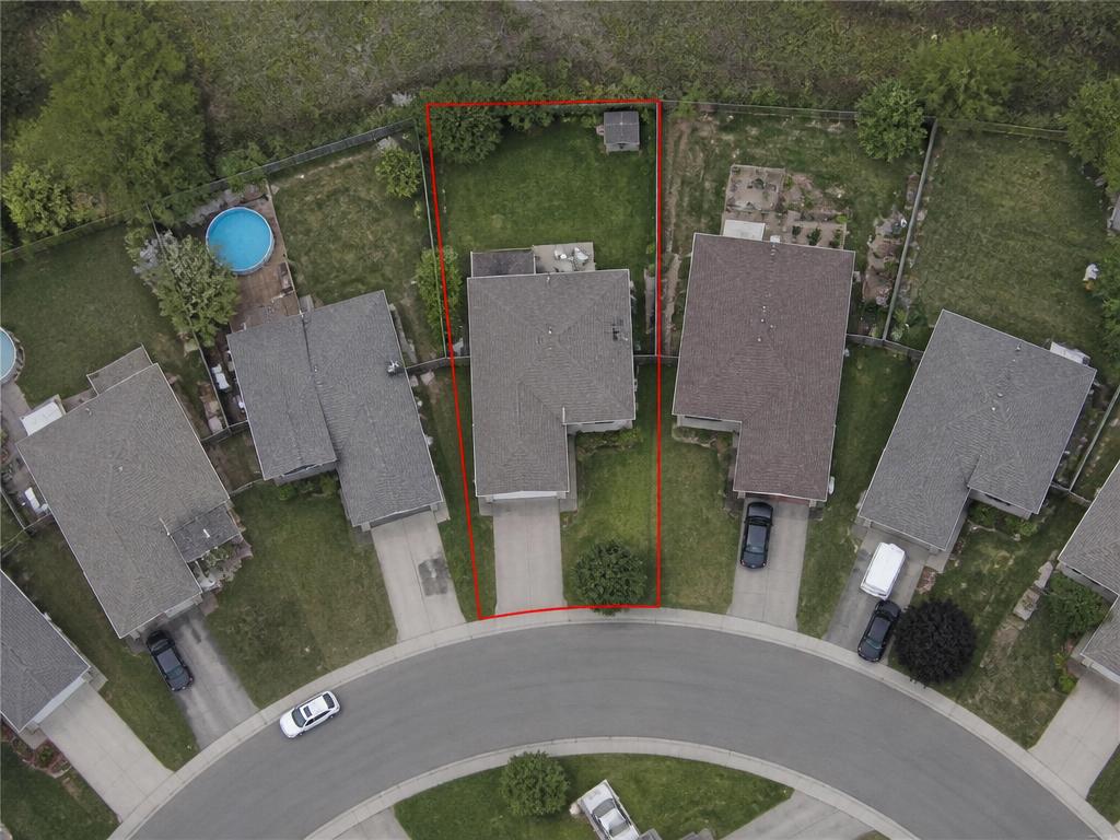 Aerial parcel photo of a suburban cul-de-sac with one parcel outlined in red, showing a single-family house rather than a commercial lot.